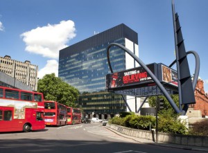daytime view of Old Street roundabout with red london bus going past